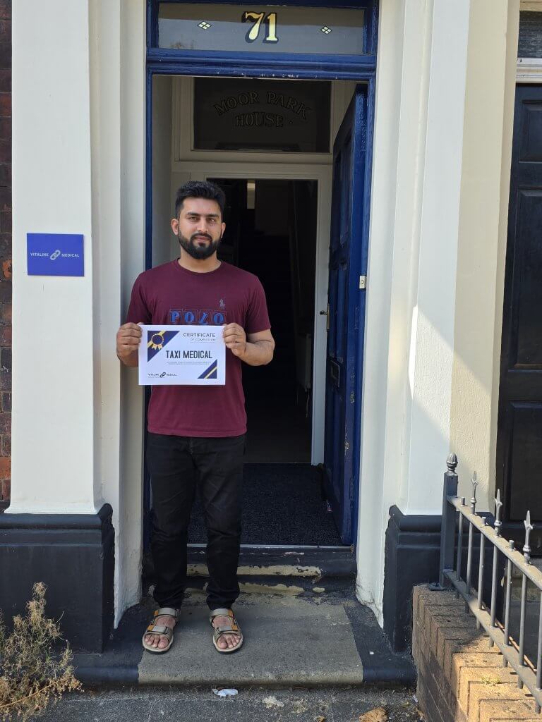 Client outside the Preston clinic with his completed taxi medical certificate from Vitalink Medical.